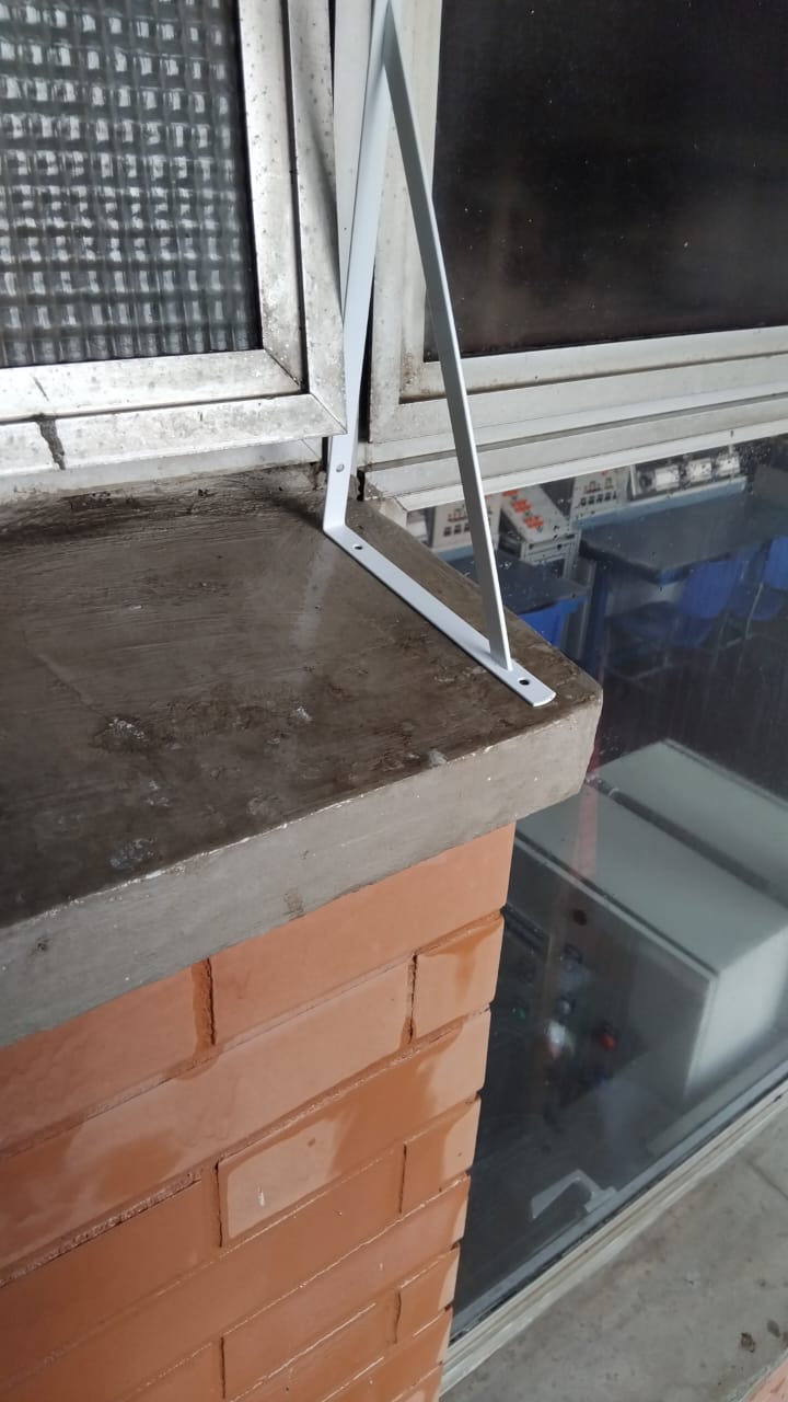 Suporte metálico instalado em parapeito para afastar pombos