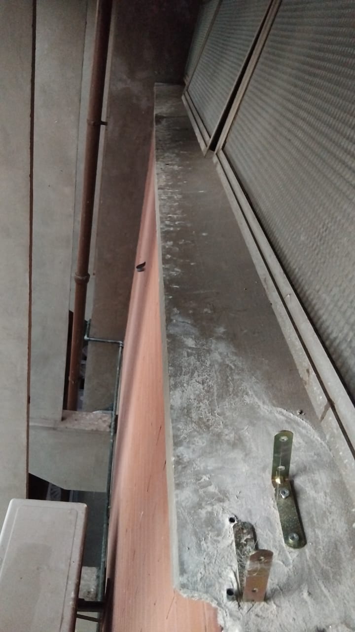 Vista ampla de telhado industrial corrugado onde pombos se instalam